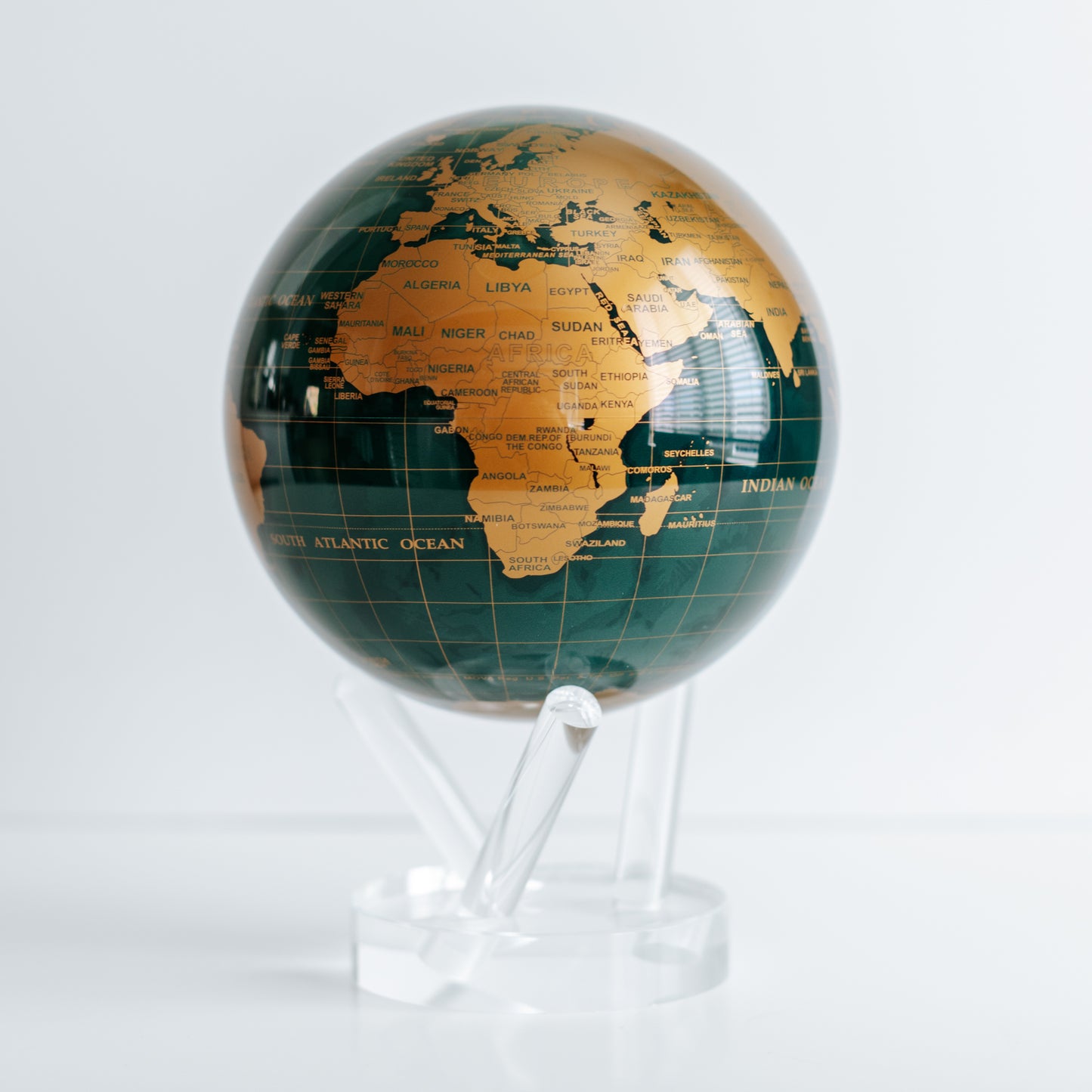 Green and Gold MOVA rotating globe with base on dining table, stylish home decoration