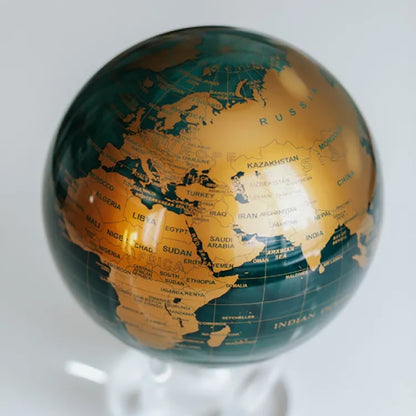 Close-up of Green and Gold MOVA rotating globe, contemporary desk ornament and sophisticated gift"