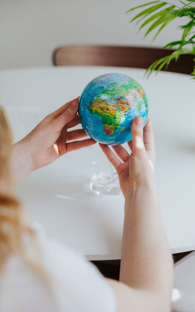 Blue relief map globe held in hands